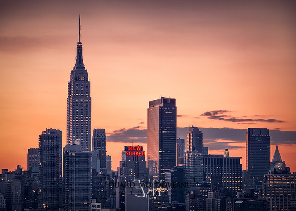 Sunrise over Manhattan skylyne with New Yorker lit up